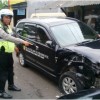 Petugas Kepolisian Polres Kuningan saat menunjukan kondisi mobil avanza yang ditabrak saat sedang parkir.